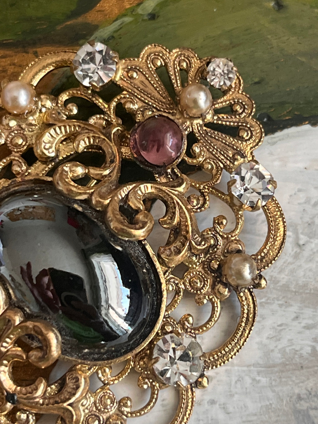 Vintage gold baroque-style brooch with black cabochon and rhinestones on gold-colored filigree