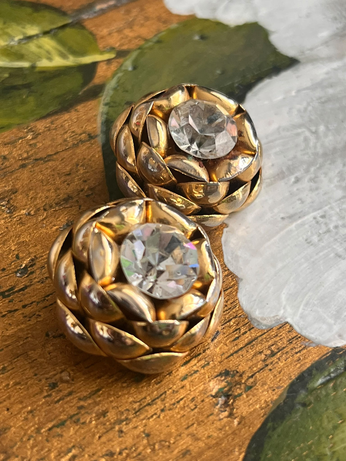 Orecchini vintage dorati a clip con grandi strass chiari, dettaglio ravvicinato